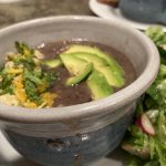 bowl of black bean soup with garnishes